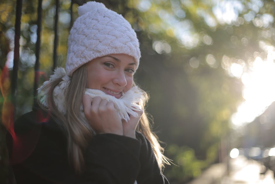 Person with closed eyes smiling peacefully while meditating outdoors.